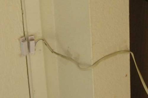 Magnetic reed switch with wire leading to door. Very simple.